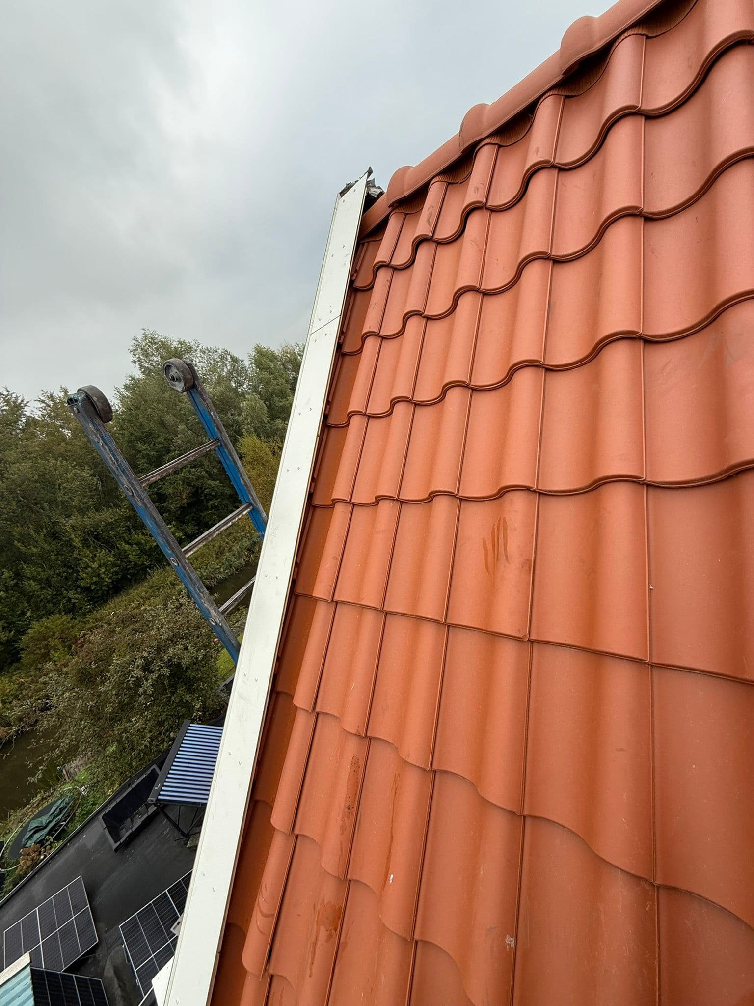 Nieuwe rode dakpannen met een strakke zinken gevelafwerking, van dichtbij