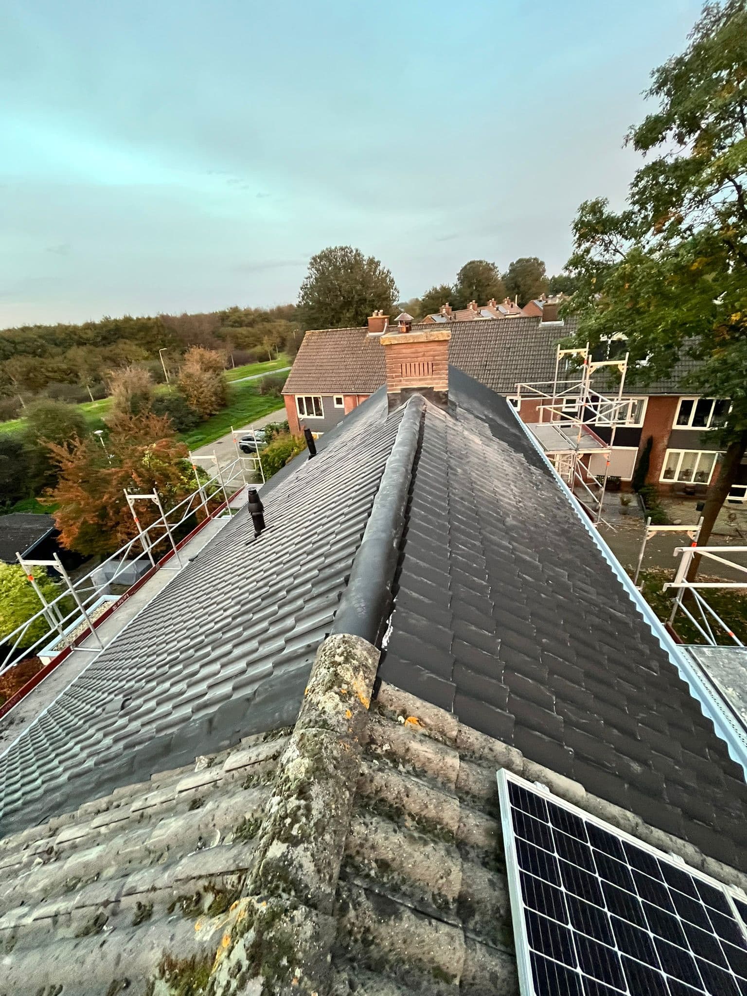 Nok van een pannendak met zonnepanelen, gezien vanaf de nokvorsten