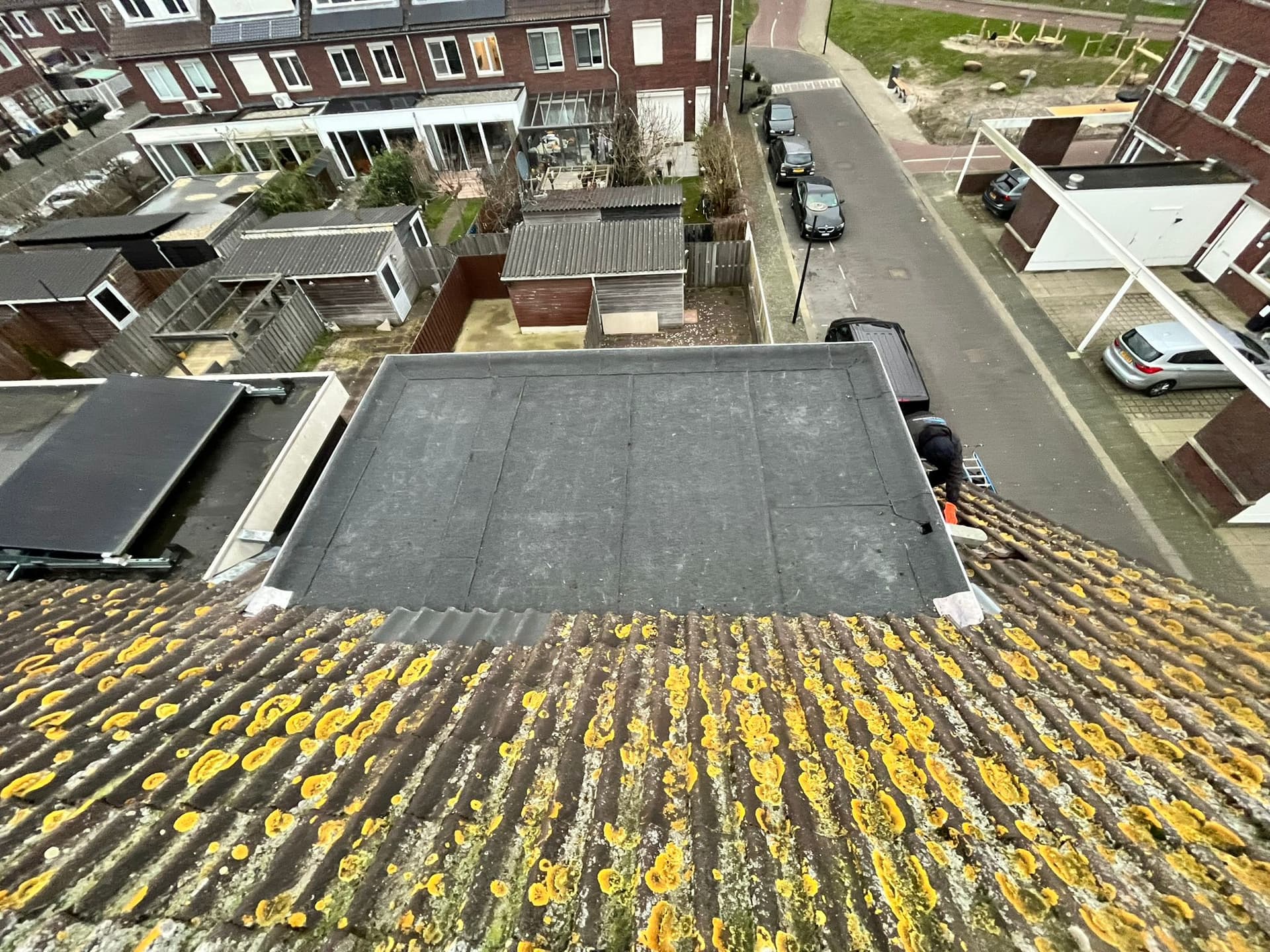 Verweerd plat dak van een aanbouw in een woonwijk, voor de vervanging
